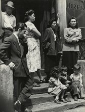 Group of men, women and children gathered on stoop, East Harlem, New York City, 1947 - 1951.