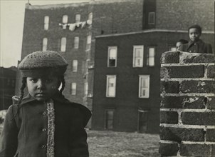 Young girl, with other children in background, in a vacant lot behind some tenement..., 1947 - 1951. Creator: Romulo Lachatanere.