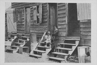 African American children sitting on the stairs in front of their house, 1922. Creator: Unknown.