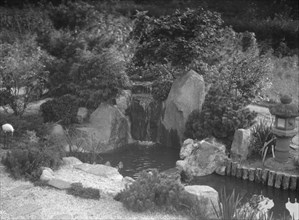 Garden with a Japanese waterfall and a stone lantern, possibly belonging to A.W. Bahr, c1917-1934. Creator: Arnold Genthe.