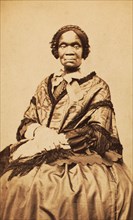 Three-quarter length portrait of unidentified woman dressed with long-fringed shawl, c1870-c1879. Creator: George W Hennigar.