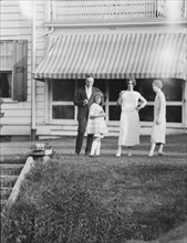 Dunning family, standing outside house, 1925 July 9. Creator: Arnold Genthe.