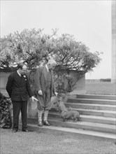 Kahn, Otto H., Mr., and unidentified man, with dog, standing outdoors, 1928 Creator: Arnold Genthe.