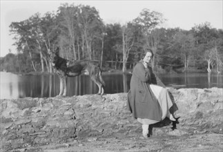 Mower, Margaret, Miss, with dog, seated outdoors, not before 1916. Creator: Arnold Genthe.