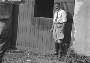Rothbart, Albert, Mr., grounds, with unidentified man standing by a stable door, c1920-1935. Creator: Arnold Genthe.