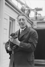 Von Lueckner, Felix, Count, with dog, standing outdoors, 1931 June 5. Creator: Arnold Genthe.