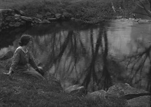 Millay, Edna St. Vincent, Miss, seated next to a pond, 1914. Creator: Arnold Genthe.
