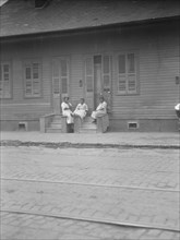 View from across street of three women talking, New Orleans or Charleston, South Ca., c1920-c1926. Creator: Arnold Genthe.