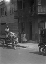 Street scene, including horse- or mule-drawn wagon, New Orleans, between 1920 and 1926. Creator: Arnold Genthe.