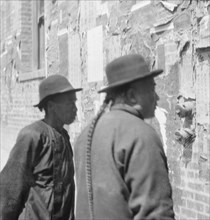 Reading wall notices, Chinatown, San Francisco, between 1896 and 1906. Creator: Arnold Genthe.