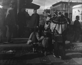 Women and children crossing a street, Chinatown, San Francisco, between 1896 and 1906. Creator: Arnold Genthe.