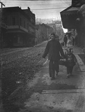 Carrying New Year's presents, Chinatown, San Francisco, between 1896 and 1906. Creator: Arnold Genthe.