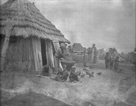 Ainu women and children outside a hut, 1908. Creator: Arnold Genthe.
