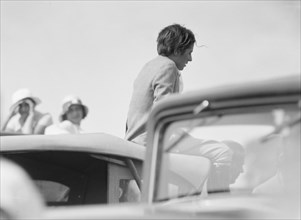 Mrs. Jack Bouvier, seated on a car, 1932. Creator: Arnold Genthe.