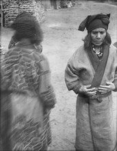 Two Ainu women in the village lane, 1908. Creator: Arnold Genthe.