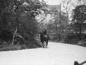 Arnold Genthe riding Chesty, between 1911 and 1936. Creator: Arnold Genthe.