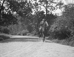 Arnold Genthe riding Chesty, between 1911 and 1936. Creator: Arnold Genthe.