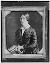 Unidentified woman, half-length portrait, facing left, seated holding book, between 1846 and 1856. Creator: Marcus Aurelius Root.
