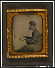 C.H. Hicks, in profile, seated at desk, between 1856 and 1858. Creator: Augustus Washington.