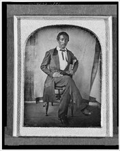 R. McGill, full-length portrait, seated in chair, facing front, with..., between 1840 and 1860. Creator: Unknown.