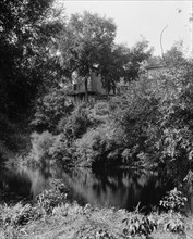 House above river, probably the Huron River, Ypsilanti, Mich., between 1900 and 1910. Creator: Unknown.