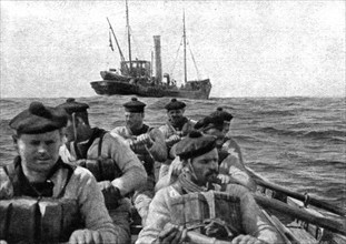 At Sea: The coastguard: boarding crew going aboard a suspect trawler..., 1917. Creator: Unknown.