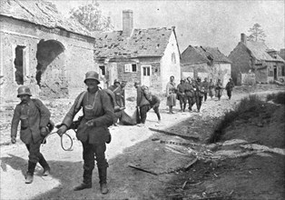'A travers le champ de bataille; prisonniers allemands traversant un village reconquis..., 1918. Creator: Unknown.