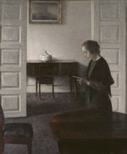 Interior with a Reading Lady, 1900. Creator: Vilhelm Hammershoi.