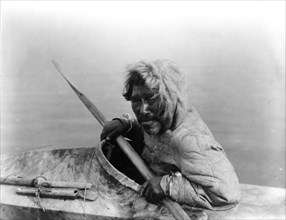 The seal-hunter, Noatak, in kayak, facing left, c1929. Creator: Edward Sheriff Curtis.