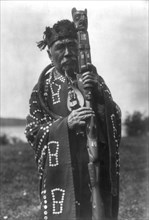 Hamasaka in Tluwulahu costume with speaker's staff-Qagyuhl [principal chief], c1914. Creator: Edward Sheriff Curtis.