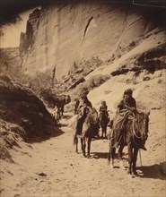 Band of mounted Navahos passing through Cañon, c1904. Creator: Edward Sheriff Curtis.