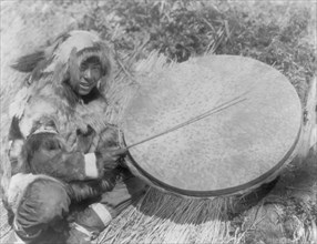 The drummer-Nunivak, c1929. Creator: Edward Sheriff Curtis.