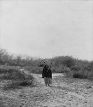 Pima woman, with burden basket on back, walking away from camera, Pima, Arizona, c1907. Creator: Edward Sheriff Curtis.