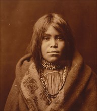 An Apache girl, head-and-shoulders portrait, facing front, wearing bead necklace..., c1903. Creator: Edward Sheriff Curtis.