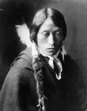 Jicarilla man, head-and-shoulders portrait, facing slightly right, with fur wrapped braids..., c1905 Creator: Edward Sheriff Curtis.