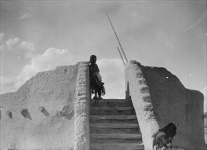 Tewa Indian guard at top of the kiva stairs, San Ildefonso, New Mexico, c1905. Creator: Edward Sheriff Curtis.