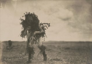 Yeibichai, the beggar, Tonenili-Navajo Indian, dressed in spruce branches, 1904, c1905. Creator: Edward Sheriff Curtis.