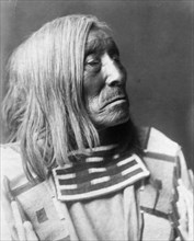 Lone Tree, an Apsaroke Indian, head-and-shoulders portrait, facing right, c1908. Creator: Edward Sheriff Curtis.
