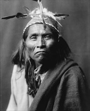 Ndee Sangochonh, Apache Indian, half-length portrait, facing front, c1906. Creator: Edward Sheriff Curtis.