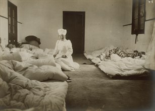 Japanese Red Cross nurses at Chemulpo attending Russian soldiers wounded in battle of Feb. 9, c1904. Creator: Robert Lee Dunn.