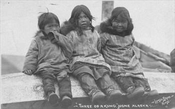 Three Eskimo children seated side by side, between c1900 and c1930. Creator: Lomen Brothers.