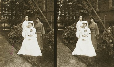 A western Red Cross female doctor(?) and two Japanese women posed in a garden, c1905. Creator: Underwood & Underwood.