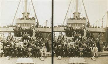 Sailors, probably American, and some civilians posed on a cruiser berthed in New York(?), c1905. Creator: Underwood & Underwood.