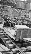 Frank G. Carpenter and man sitting on tracks, between c1900 and 1924. Creator: Unknown.