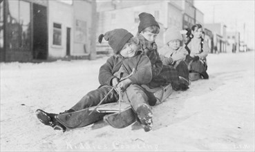 Children sleigh riding, between c1900 and c1930. Creator: Unknown.