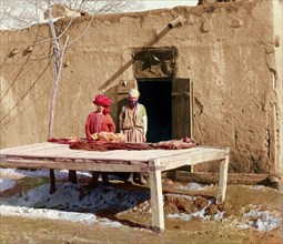 Vendors beside table displaying flatbread, between 1905 and 1915. Creator: Sergey Mikhaylovich Prokudin-Gorsky.
