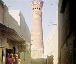 Street scene with vendors, minaret in background, between 1905 and 1915. Creator: Sergey Mikhaylovich Prokudin-Gorsky.