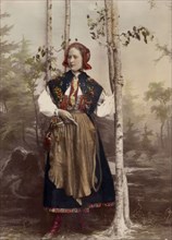 Woman in full figure dressed in costume from Floda parish, Dalarna, 1890-1920.  Creator: Helene Edlund.