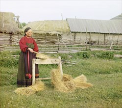 Peasant woman breaking flax;Perm Province, 1910. Creator: Sergey Mikhaylovich Prokudin-Gorsky.