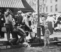 Summer scene, N.Y. - drinking water from street pump, between c1910 and c1915. Creator: Bain News Service.